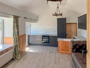 a large kitchen with a couch and a table at Post Office Lodge in Manish