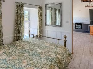 a bedroom with a bed and a mirror at Post Office Lodge in Manish