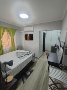 a bedroom with a bed and a desk and a television at Oloks Guest Inn in Francistown
