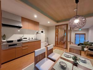 a kitchen and living room with a table and chairs at 和居 琉璃 和を感じるレイアウトで心も体も休まる宿 in Wada