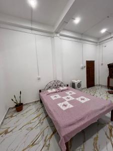 a bedroom with a bed with a purple blanket at Dharitry Homestay Majuli in Mājuli Island