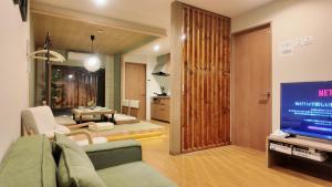 a living room with a couch and a tv in it at 和居 琉璃 和を感じるレイアウトで心も体も休まる宿 in Wada