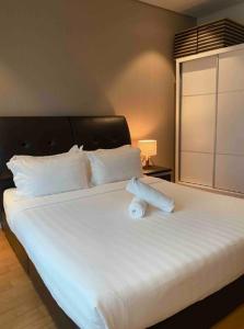 a large white bed with two rolled towels on it at Stella Maison KLCC in Kuala Lumpur