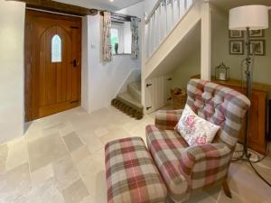 a living room with a couch and a chair at Folly Cottage in Avening