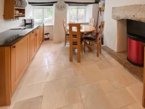 a kitchen with a table and a dining room at Folly Cottage in Avening