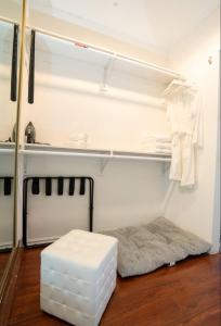 a white room with a bed and a white stool at silver in Chatsworth