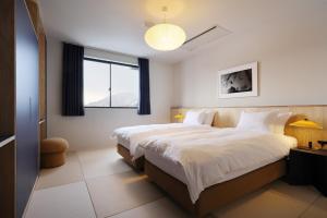 a bedroom with a large bed and a window at evo Hotel Hakuba in Hakuba