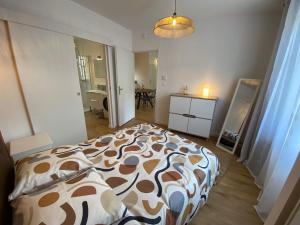 a bedroom with a bed with a brown and white comforter at Le Cocon de Langes in Orange