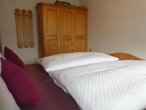a bedroom with a bed and a wooden cabinet at Gästehaus Bergblick in Wallgau