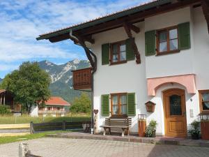 a building with green shutters and a bench in front at Gästehaus Bergblick in Wallgau