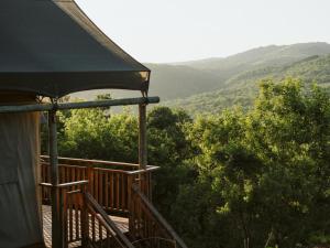 a balcony of a house with a view of the mountains at Matatane Camp - Babanango Game Reserve in Babanango