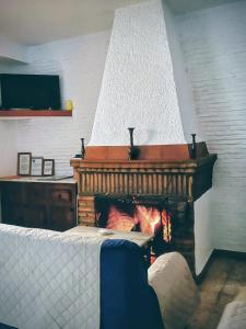 a fireplace in a living room with a fire at casa rural Ribera del Hueznar in Constantina