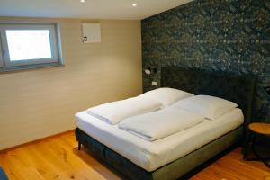 a bedroom with a bed with white pillows on it at Ferienhaus DONAUzeit in Sigmaringen
