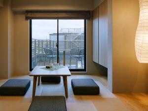 a living room with a table and a large window at Minn Gion Sanjo in Kyoto