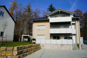 a large white house with a stone wall at Ferienhaus DONAUzeit in Sigmaringen
