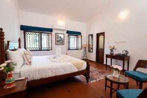a bedroom with a bed and a table and chairs at Quinta da Praia by Semper Felix in Calangute +64 photos