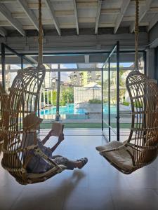 a person sitting in a hammock reading a book at Treevana Club Chiangmai in Chiang Mai