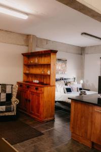a bedroom with a bed and a wooden dresser and a desk at La Rona Hospitality Services in Rustenburg