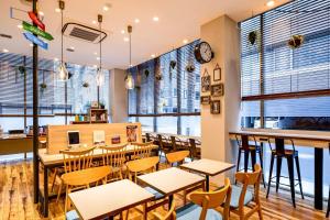 a restaurant with tables and chairs and windows at Comfort Hotel Tokyo Kanda in Tokyo