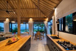 a kitchen and living room with a view of the ocean at Villa Utopia in Nusa Lembongan