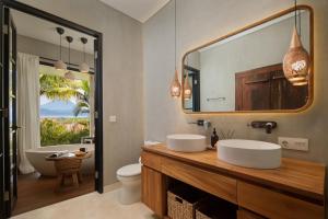 a bathroom with two sinks and a tub and a mirror at Villa Utopia in Nusa Lembongan +52 photos