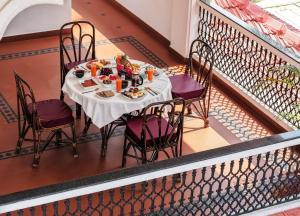 a table and chairs on a balcony with food on it at Quinta da Praia by Semper Felix in Calangute