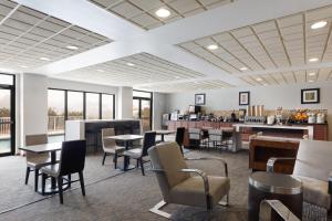 a restaurant with tables and chairs and a bar at Wingate by Wyndham Destin in Destin