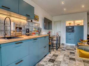 a kitchen with blue cabinets and a counter at Country Lodge - Heuboden in Tating +28 photos