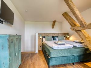 a bedroom with two beds and a tv on the wall at Country Lodge - Heuboden in Tating