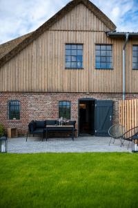 a building with a patio with a couch and a table at Country Lodge - Heuboden in Tating