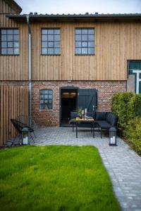 a patio with chairs and a table in front of a building at Country Lodge - Stall in Tating