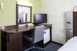 a room with a desk with a computer and a mirror at Comfort Hotel Niigata in Niigata