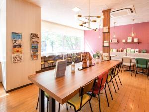 a conference room with a large wooden table and chairs at Comfort Hotel Maebashi in Maebashi