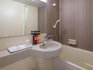 a bathroom with a sink and a bath tub at Comfort Hotel Nara in Nara