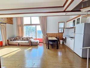a kitchen and living room with a couch and a table at Sanbangsan Hot Spring Pension in Seogwipo