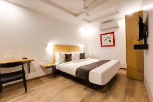 a bedroom with a bed and a desk in a room at Townhouse Derawal Nagar in New Delhi