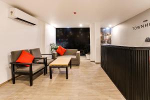 a lobby with chairs and a couch and a bar at Townhouse Derawal Nagar in New Delhi +30 photos