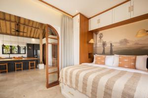 a bedroom with a large bed and a kitchen at Villa Utopia in Nusa Lembongan