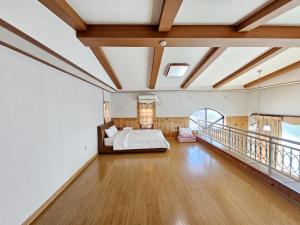 a bedroom with a bed and a balcony at Sanbangsan Hot Spring Pension in Seogwipo +69 photos