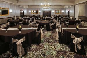 a banquet hall with tables with black tablecloths at Lakeside Hotel Casino, a Travelodge by Wyndham in Osceola
