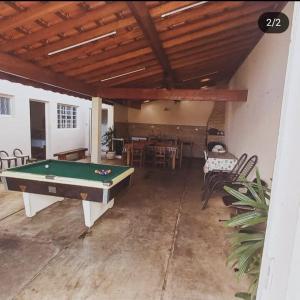 a living room with a pool table and chairs at Edicula Paz e Amor in Piracicaba