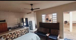 a room with a bed and a kitchen with a ceiling fan at Edicula Paz e Amor in Piracicaba +11 photos