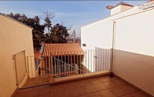 a balcony of a building with a dog in a cage at Edicula Paz e Amor in Piracicaba