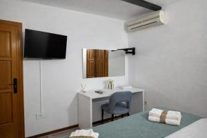 a hotel room with a desk and a bed and a monitor at Mini Peixcateria B in Sagunto