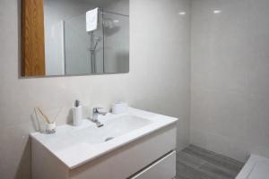 a white bathroom with a sink and a mirror at Mini Peixcateria B in Sagunto