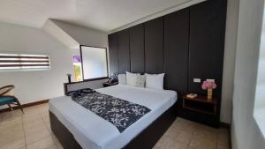a bedroom with a large bed with a black headboard at Grand Hotel Excelsior Port Royal in Kingston +19 photos