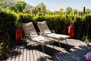 two chairs sitting on a deck with red vases at De Wingerd Wijnland Lodge in Paarl +35 photos