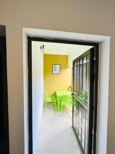 a dining room with a green table and a window at Résidence Ephrata in Cocody +3 photos