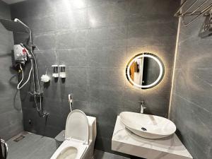 a bathroom with a sink and a toilet and a mirror at Mai Phương Motel in Pleiku