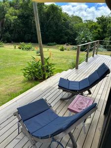 two lounge chairs and an umbrella on a deck at Eco Lodge Chamarel in Chamarel +5 photos